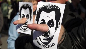 A demonstrator use fingers in the place of the nose with an image of Sarkozy, France's President and UMP party candidate for the 2012 French presidential election, referring to him as Pinocchio during the traditional labour union Labour Day march in Paris